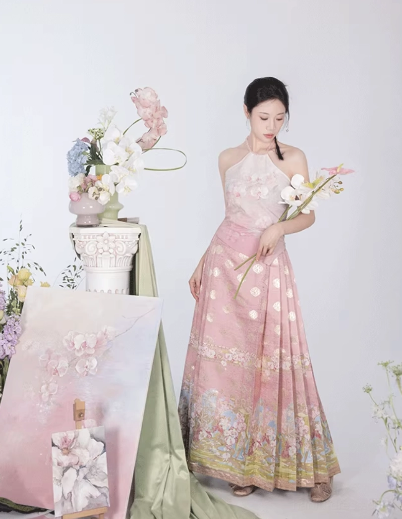 Full body model wearing pink modern Hanfu mamian skirt with fitted halter top and golden decorative hem