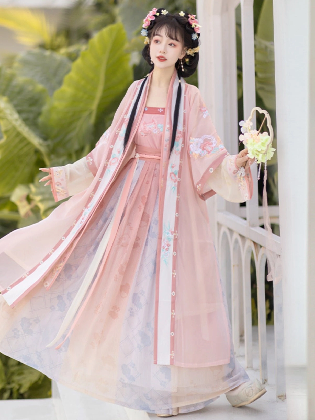 Pink Qiyao Ruqun Hanfu side view showing the flowing gradient chiffon skirt, long silk-style waist ribbons, embroidered outer coat, and lightweight movement
