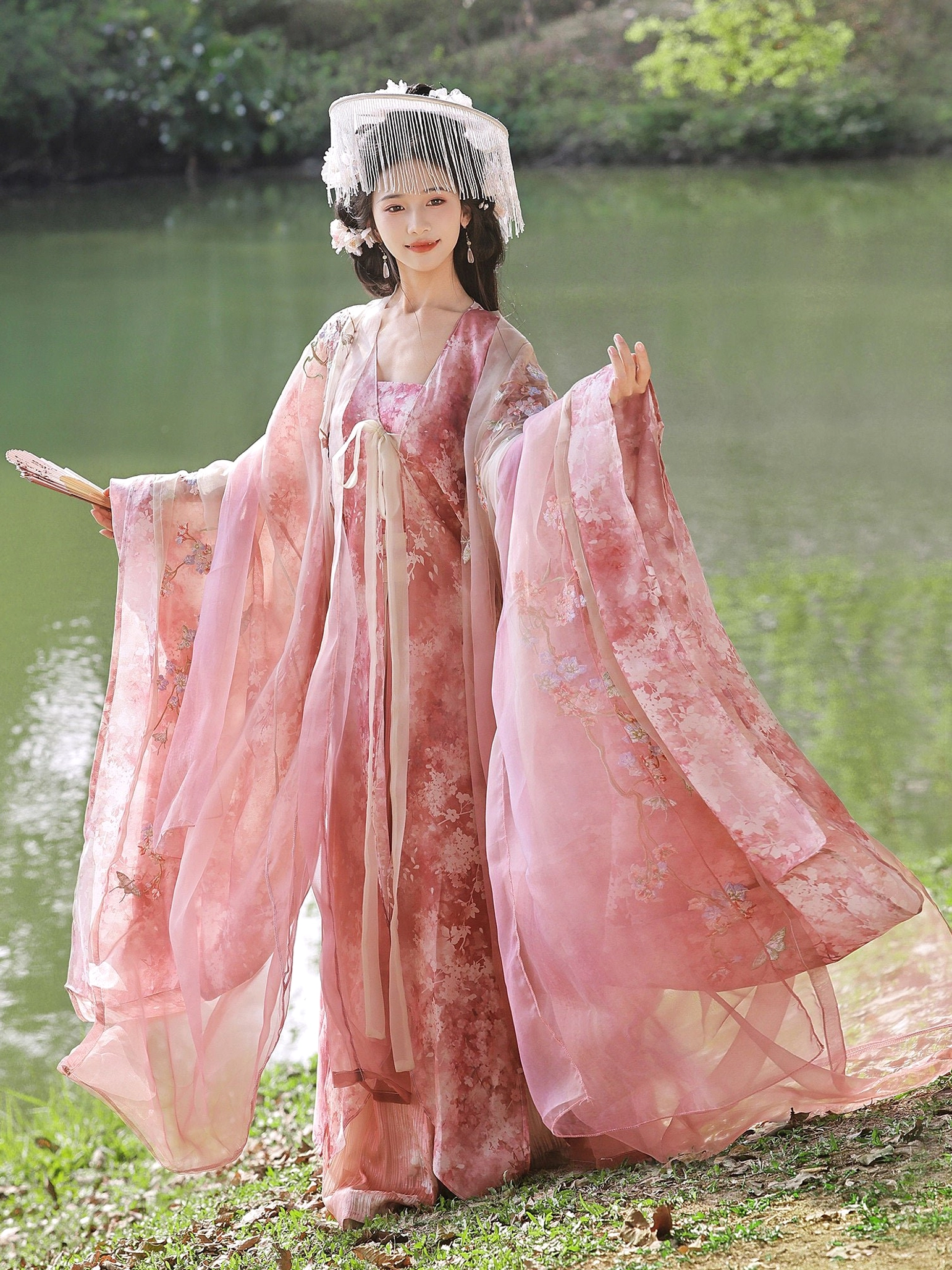 Full-length pink Tang Dynasty Hanfu outfit with layered skirt, lightweight outer robe, and elegant wide sleeves viewed from the front