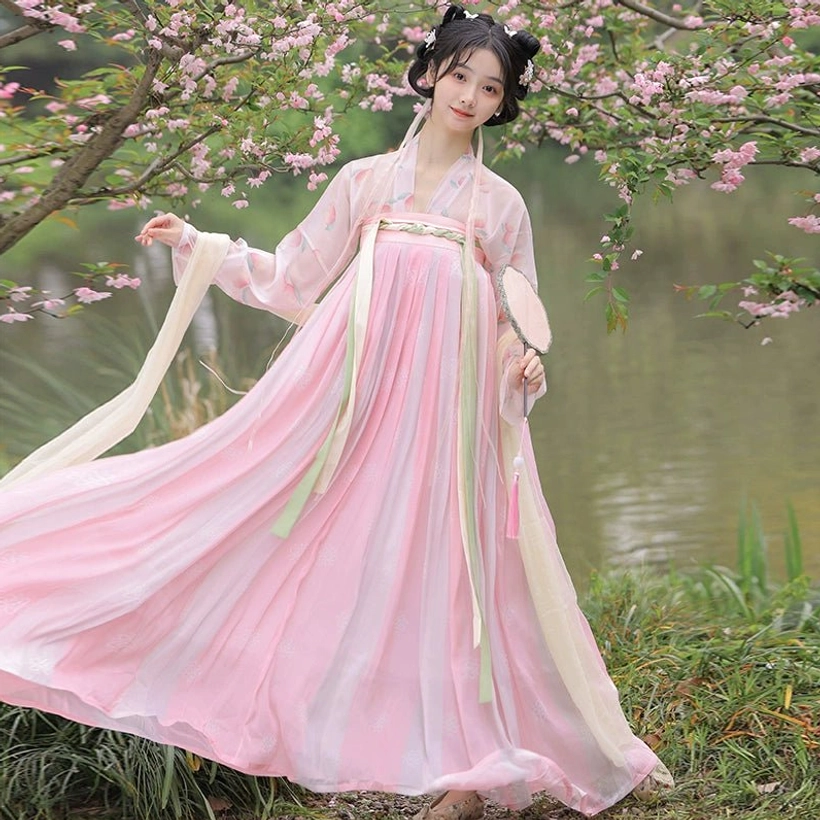 Side view of a pink Tang Dynasty Qixiong Ruqun Hanfu with a full pleated skirt, pale pink top, and long flowing shoulder sashes moving in the breeze