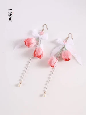 Pink tulip bow dangle Hanfu earrings with white lace bows, gold chain tassels, and pearl-tipped drops displayed on a light gray background