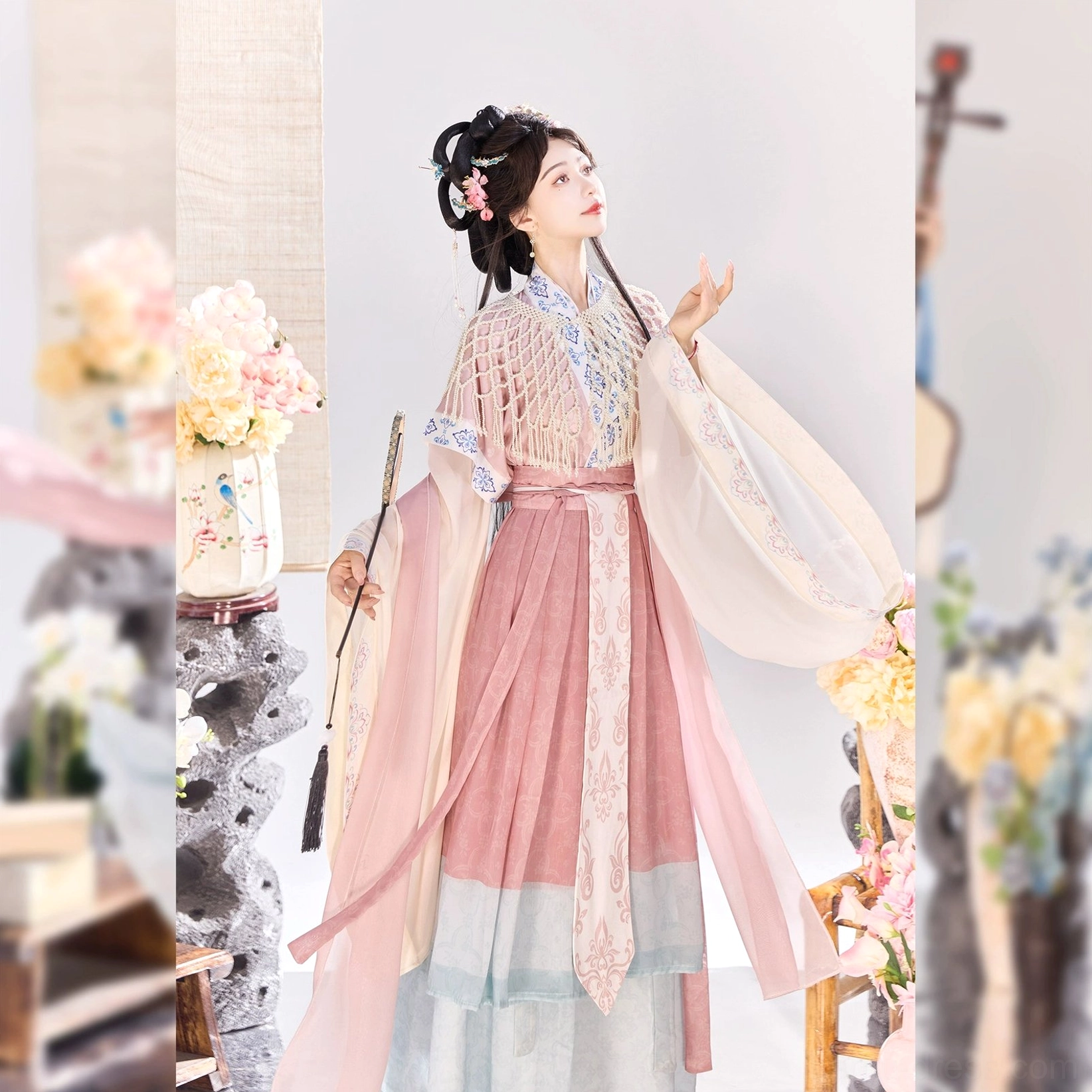 Pink Wei Jin Dynasty Qiyao Ruqun Hanfu shown from a side angle with flowing sheer sleeves, embroidered cropped yoke, floral waist sash, and layered pink skirt with pale blue hem