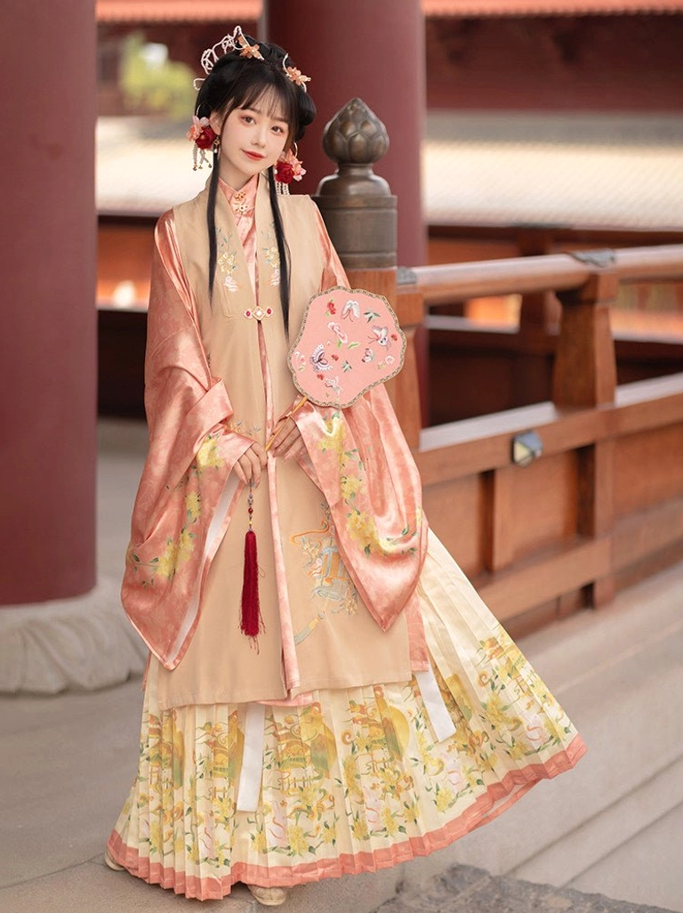 Pink and yellow Ming Dynasty hanfu colorway featuring a cream bijia vest, salmon wide-sleeve robe, printed pleated skirt, and pink embroidered round fan