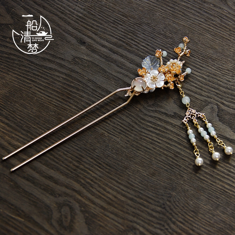 Back view of plum blossom Chinese hair stick showing gold-tone floral branch design and short beaded tassel detail