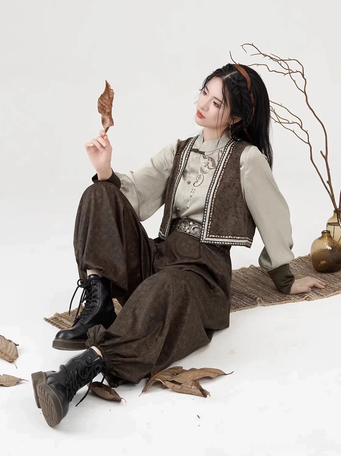 Relaxed seated view of a woman wearing the coordinated Poetry of the Wilderness modern Hanfu set in earthy brown tones