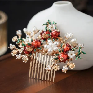 Close-up of pomegranate Hanfu side hair comb with red enamel-style pomegranates, faux pearls, green leaves, small flowers, rhinestones and gold-tone metal frame