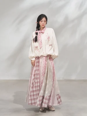 Front full-body view of a modern Hanfu xianxia coat and patchwork maxi skirt outfit in cream and powder pink with floral embroidery and puff sleeves