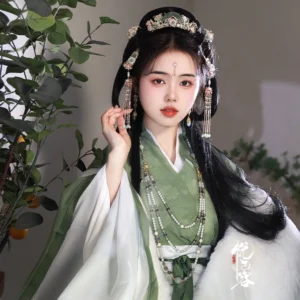 Side view of a woman wearing traditional Chinese Hanfu hair accessories with forehead crown ornament, layered styling, and long green tassel hairpins