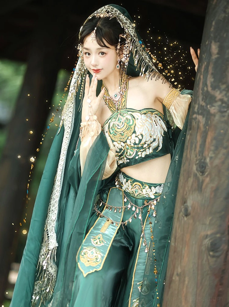 Three-quarter front view of a Dunhuang Feitian Tang Dynasty Hanfu dance costume with embroidered crop top, beige sheer lantern sleeves, beaded tulle headdress, waist ornaments, and flowing green veil in an outdoor pavilion