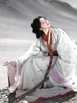 Princess of Qin Han Dynasty straight hem Hanfu robe in off white with red floral motifs, wide sleeves and red waist sash in a desert mountain setting
