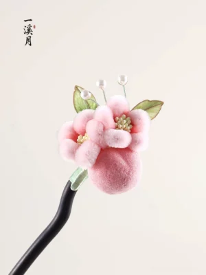 Puffy pink plush flower Chinese hair stick with green leaves and pearl accents shown from an angled top view