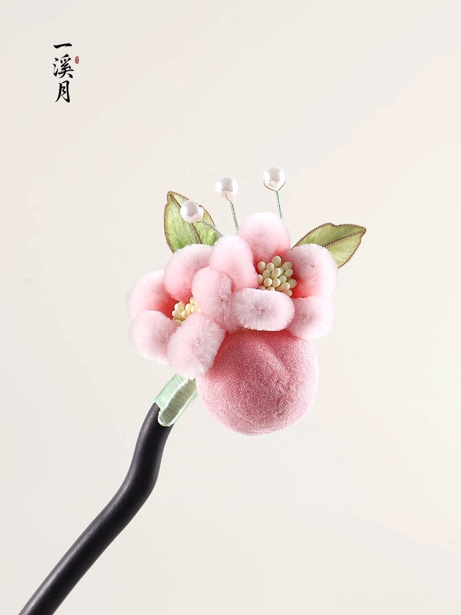 Puffy pink plush flower Chinese hair stick with green leaves and pearl accents shown from an angled top view