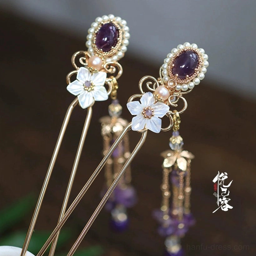 Vintage Chinese purple tassel hair pin with gold-tone frame oval purple gemstone pearl border white shell flower charm and dangling beaded tassel displayed on dark wood