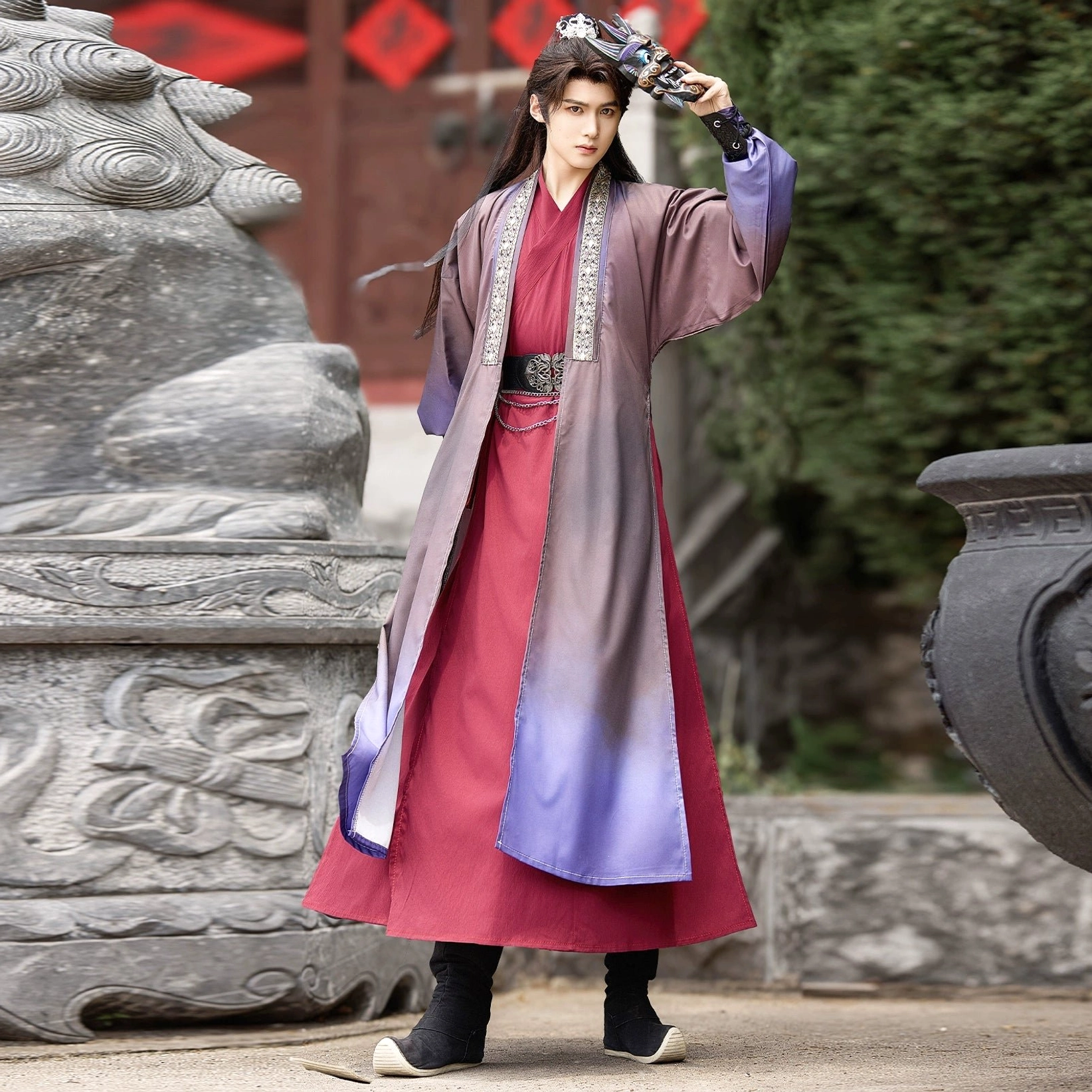 Full-body side-front view of a men's Hanfu Ghost King costume with purple gradient cross-collar robe, embroidered collar, matching belt, ghost mask styling, and traditional hair crown in an ancient courtyard