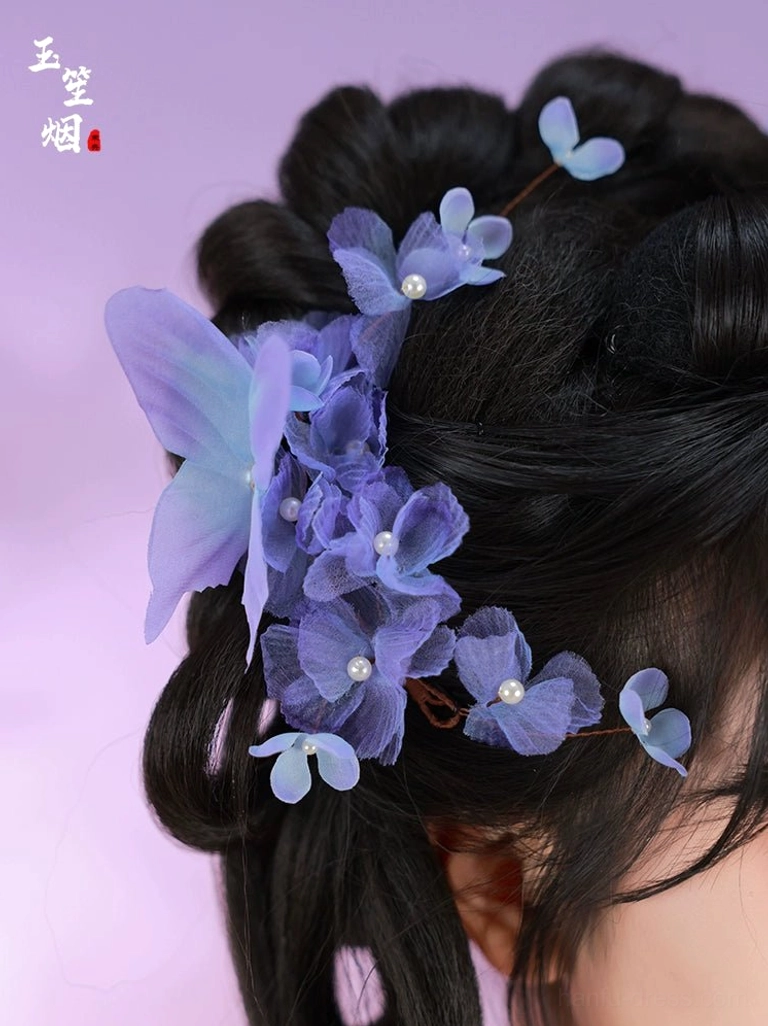 Purple floral Hanfu hair pins arranged in the back of a traditional Chinese updo with layered blossoms and pearl-like accents