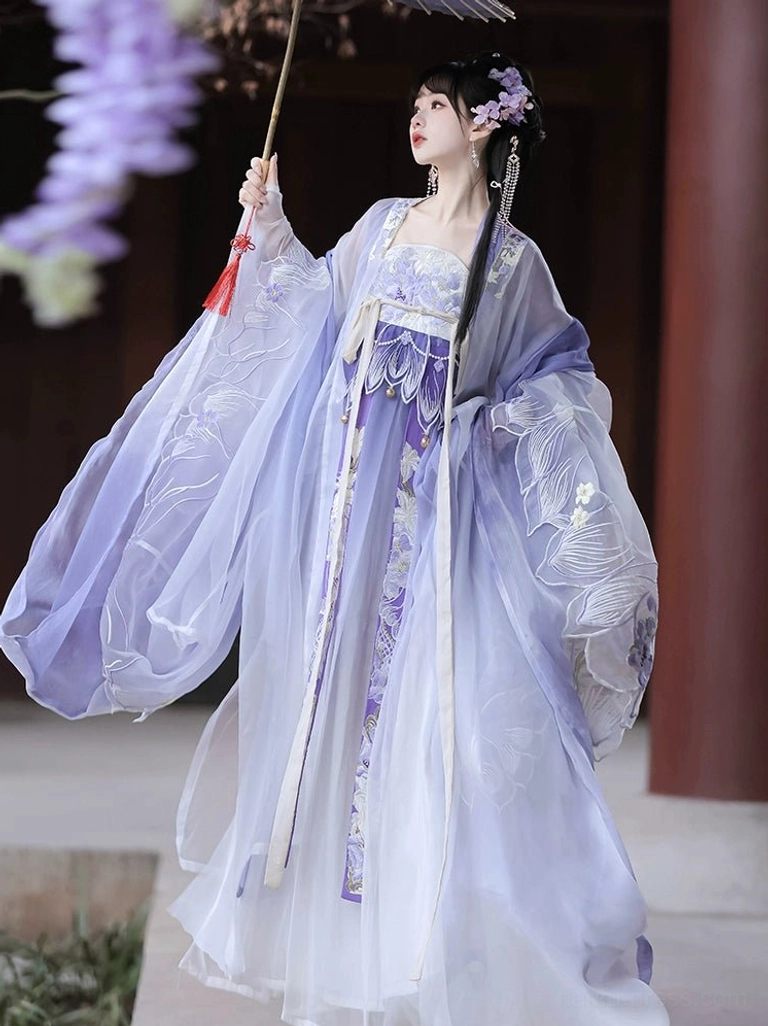 Purple gradient Tang Dynasty Heziqun Hanfu dress with wide sheer sleeves, floral embroidery, flowing skirt, and tasseled Chinese paper umbrella in a wisteria courtyard