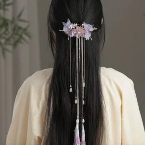 Rear view of long black hair styled with a purple Hanfu hair pin and flowing tassel chains worn with a beige traditional Chinese outfit