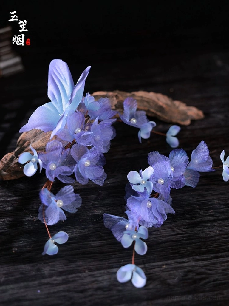 Purple iris flower and butterfly Hanfu hair pins flat lay with translucent petals and pearl-like flower centers on dark wood