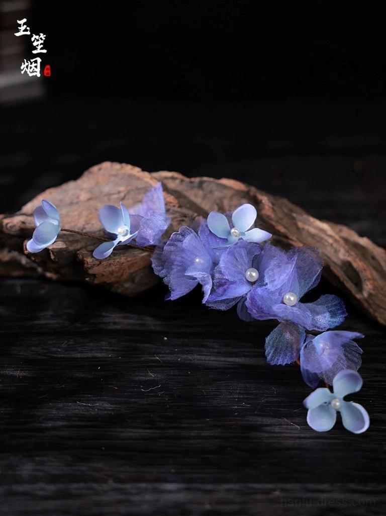 Compact purple iris floral Hanfu hair pin pair with layered translucent violet flowers photographed on dark wooden surface