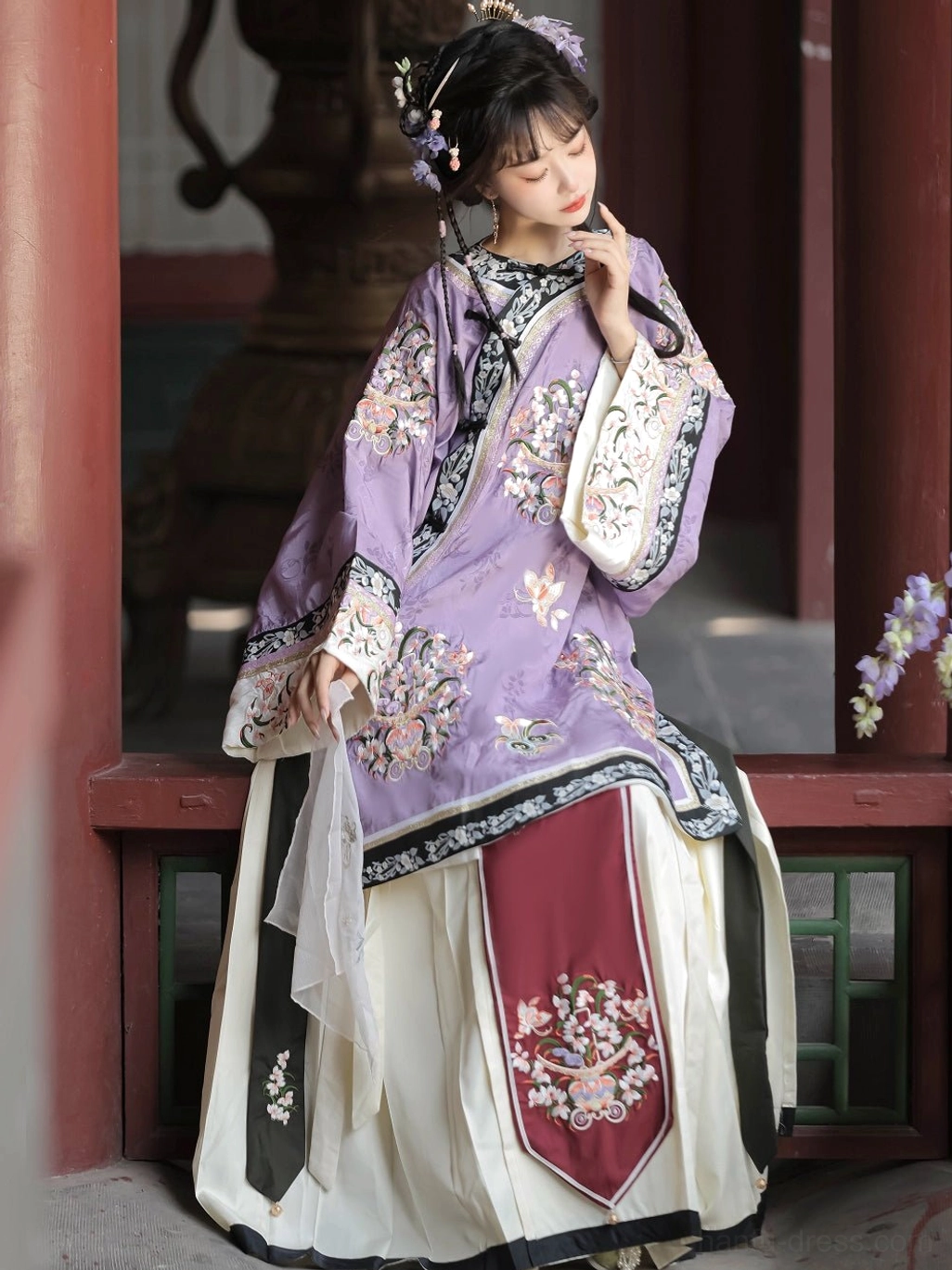Close-up view of a purple Qing Dynasty Han women's blouse showing floral embroidery, ornate collar trim, and detailed sleeve cuffs