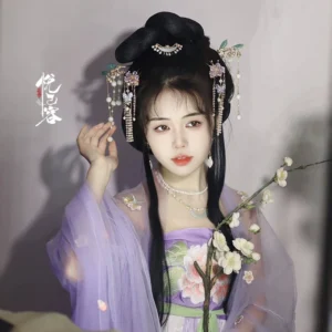 Female model wearing a purple Tang-style hanfu outfit and Chinese flower tassel hairpin with an elegant traditional hair bun