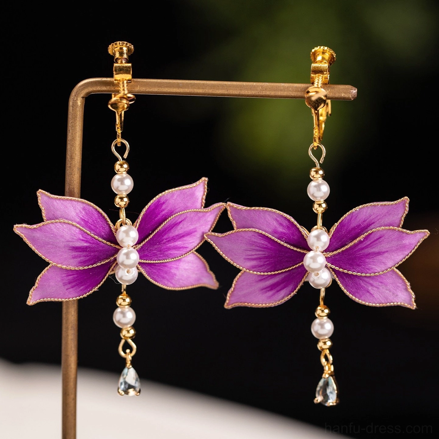 Close up of purple velvet lotus flower comfort clip-on Chinese earrings with layered pearl centers and polished gold tone details