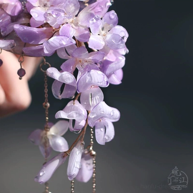 Macro close-up of translucent gradient purple wisteria flowers and delicate dangling bead chains on a traditional Chinese hair stick