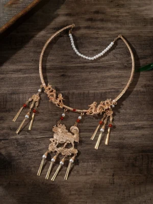 Overhead view of an ornate Qilin Chinese neck ring necklace featuring carved gold-tone collar details, freshwater pearl chain, red gemstone accents, mythical pendant, and long metal tassel ornaments
