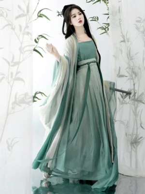 Qing Dai Song Dynasty style Qiyao Ruqun Hanfu shown from a front three quarter view with a teal green camisole, ivory wide sleeve chiffon outer robe, high waisted flowing skirt, and matching waist sash