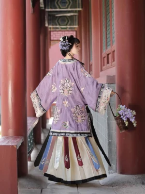 Back view of a purple Qing Dynasty Han women's blouse with wide sleeves and embroidered details, styled with a layered traditional Chinese skirt