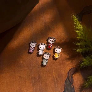 Qing palace cat empress stud earrings in five colorful court-inspired Hanfu outfits displayed on a vintage wooden tabletop