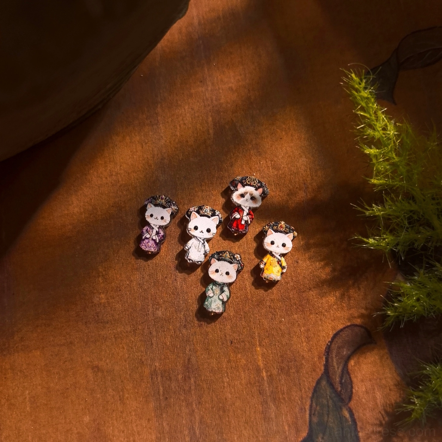 Qing palace cat empress stud earrings in five colorful court-inspired Hanfu outfits displayed on a vintage wooden tabletop