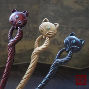 Qingqiu fox Chinese hair stick collection in three wood colors with twisted carved shafts, fox head details, and turquoise eye inlays displayed in a traditional Hanfu-inspired setting