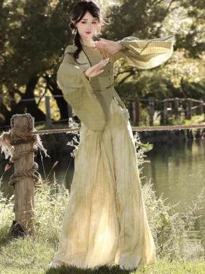Side view of Qingti Modern Hanfu outfit with flared sleeve stand-collar top and green to beige gradient wide-leg pants by a lakeside