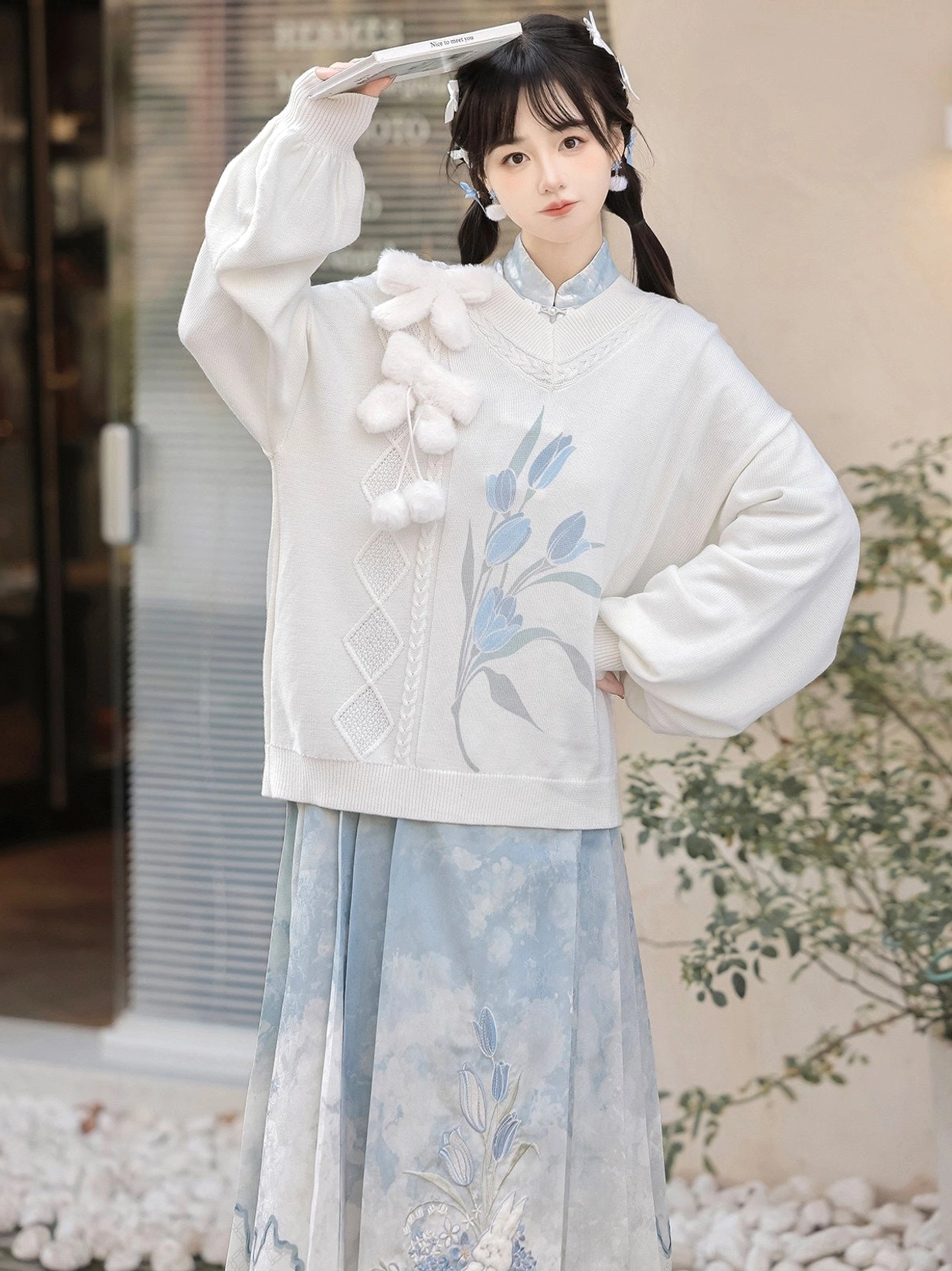 Close up of white rabbit inspired modern Hanfu sweater collar and decorative pom pom details with blue Mamianqun skirt
