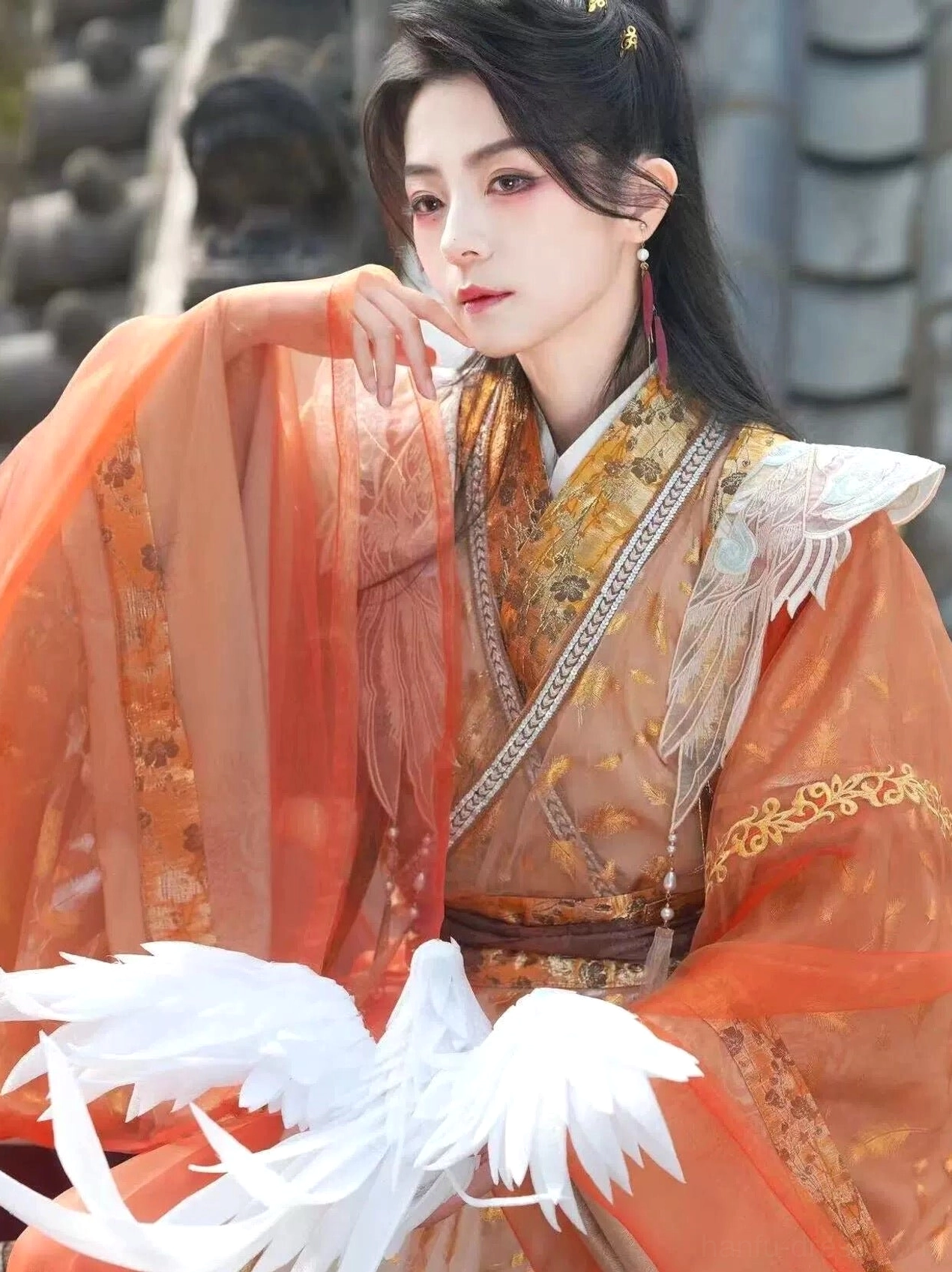 Close-up of Radiance xianxia hanfu costume featuring wing-shaped cloud collar embroidery, gold trimmed cross collar, and sheer orange outer layer