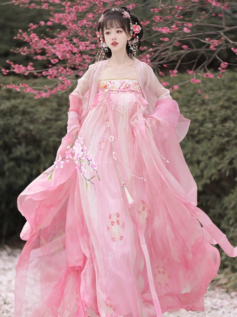 Pink Tang Dynasty Qixiong Ruqun Hanfu with sheer wide sleeves, floral printed skirt, chest ornament, and tassel accessories in a blooming garden