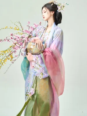 Rainbow Iris Qiyao Ruqun Hanfu shown from a side three-quarter view with embroidered beizi coat camisole gradient sheer sleeves high-waisted green skirt and floral vase