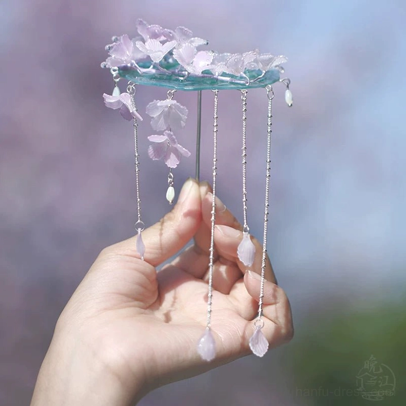 Raining cherry blossoms hair accessory with a circular cyan base sparse floral clusters long silver chains and teardrop pendants