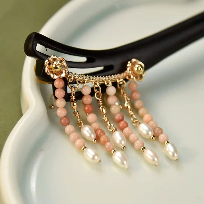 Detailed close-up of Chinese hair stick tassels with gradient pink brown beads, rice-shaped freshwater pearls and delicate gold chains