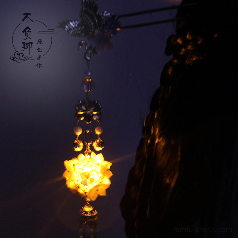 Rear view of a Chinese glowing lantern hair stick worn in an ancient braided hairstyle with layered beaded chain, crane ornament, and hanging tassel