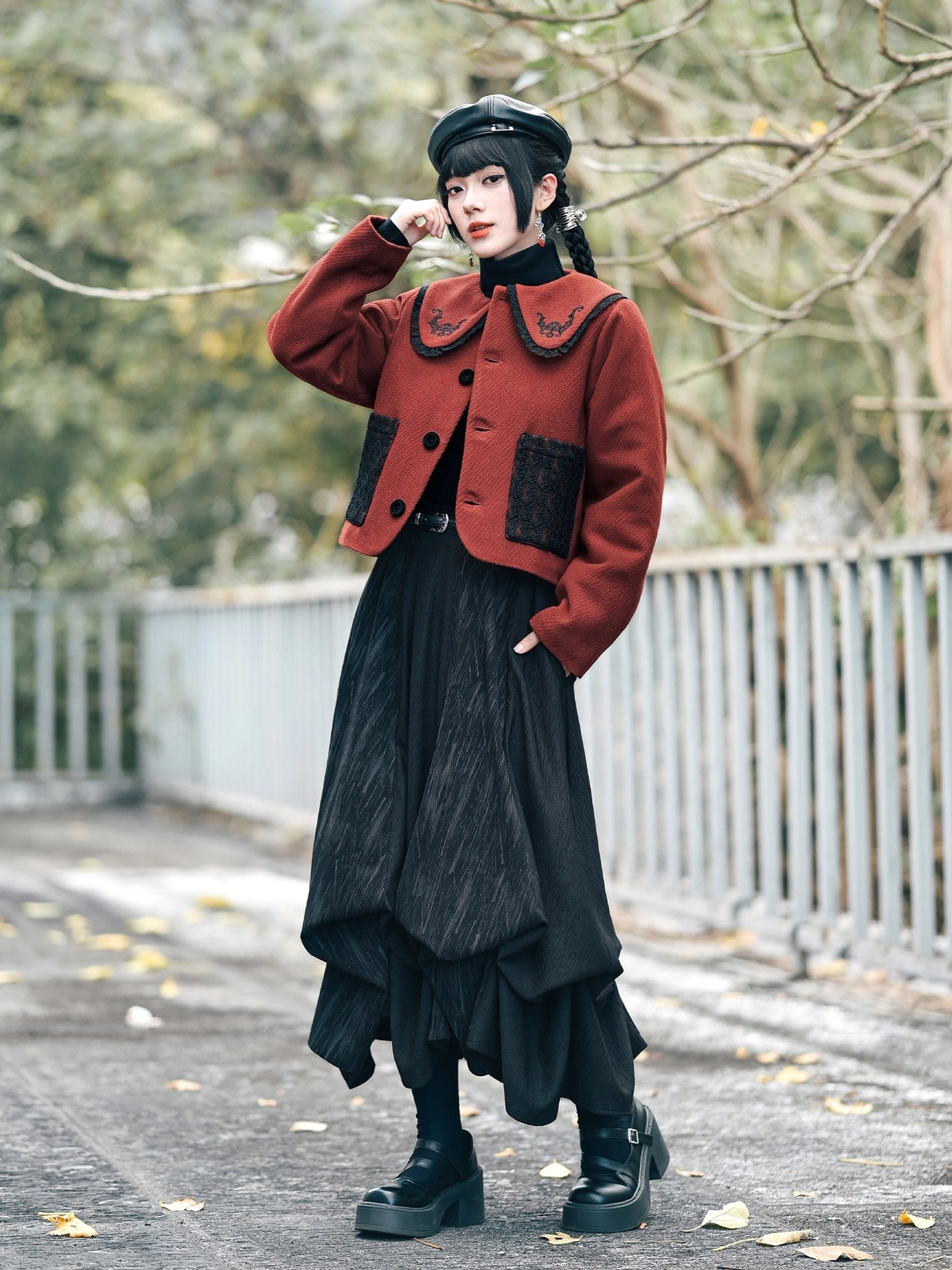 Three-quarter side view of a red and black lucky bat embroidered cropped Chinese jacket showing the fitted silhouette, collar detail, and neat side profile
