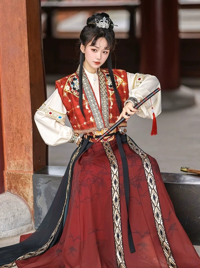 Red and black Tang-style hanfu swordsman outfit shown in a seated pose with embroidered vest metallic trim tassel waistband and bamboo print wrap skirt