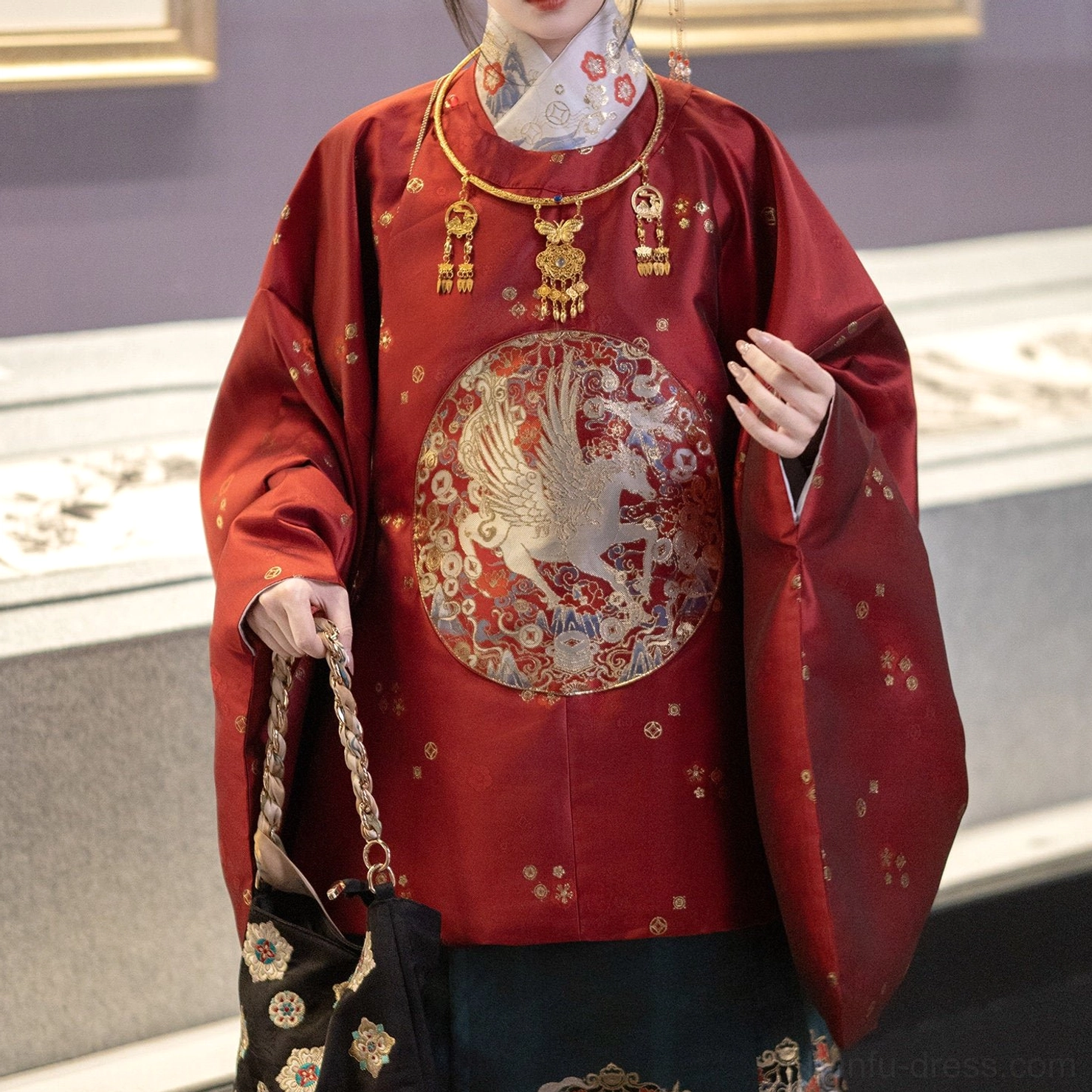 Close-up of red Chinese New Year Hanfu round-collar top with crane medallion and golden floral dot pattern