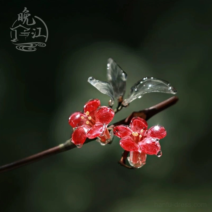 Reverse side close-up of a red crabapple blossom Chinese hair stick with clear green leaves and a warm brown decorative hair stick stem