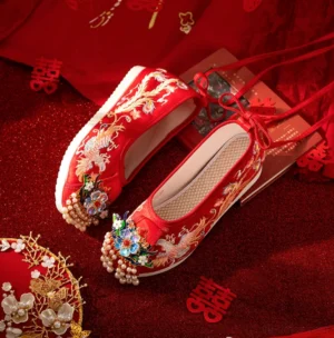 Side view of red Chinese bridal Hanfu wedding shoes showing gold dragon phoenix embroidery tassel ornaments and raised rubber platform sole