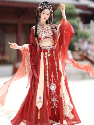 Red Dunhuang Feitian Hanfu costume shown from the side with an embroidered cropped bust top, gradient red chiffon sleeves, long layered skirt, golden tassels, and decorative waist jewelry