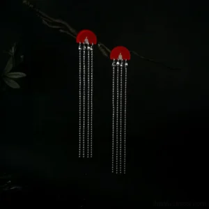 Red fan-shaped Chinese tassel earrings displayed on a dark branch against a black studio background, featuring scarlet semicircle stud tops, polished silver bead chains, and elegant Cheongsam jewelry styling