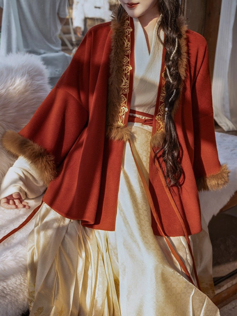 Close-up of red festive Hanfu jacket with plush collar and cuffs, gold trim, layered cross-collar top and brown mamian skirt