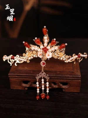 Central crown hairpin from a red and gold Hanfu hair accessories set featuring intricate filigree, cherry blossom decoration, pearl tassel, and hanging beads
